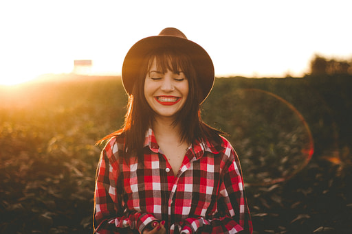 Woman smiling in field | Fall bucket list 10 impactful fall activities