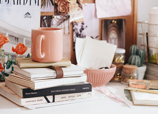 vision board | desk with books mug plant and visual cutouts