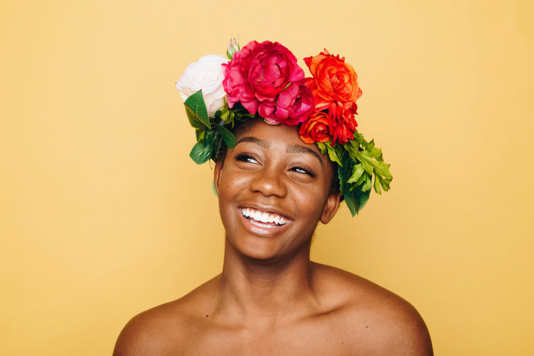 Woman with flower crown against a yellow background | 10 best holiday gift ideas for meaningful gifts