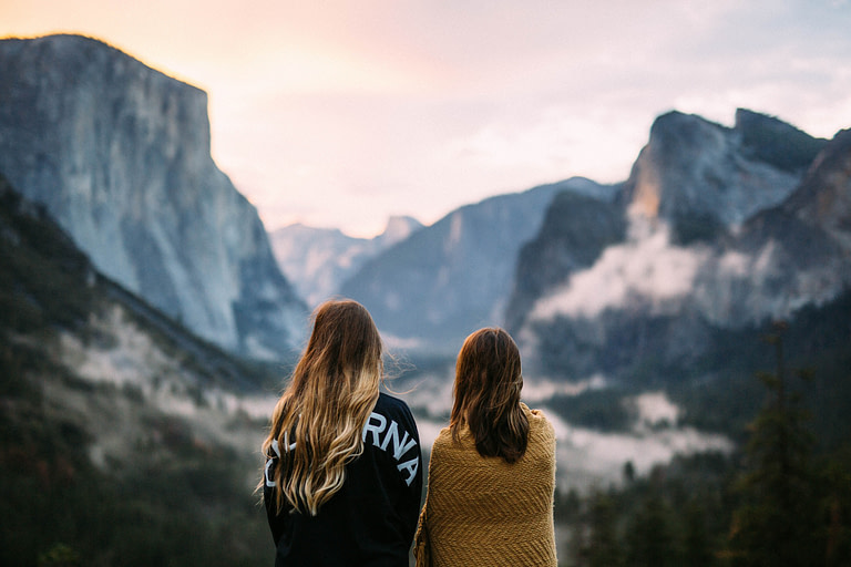 Two women sitting together on top of a mountain | 10 best holiday gift ideas for meaningful gifts